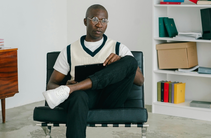 Man with clipboard sitting in chair.