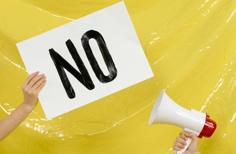 A protest sign reading ‘NO’ held alongside a megaphone.